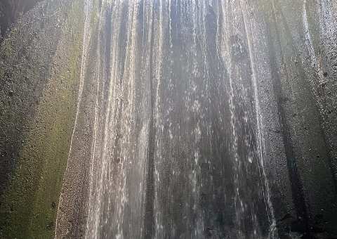 Tukad Cepung Waterfall — A curtain of sunlight piercing a narrow stone canyon